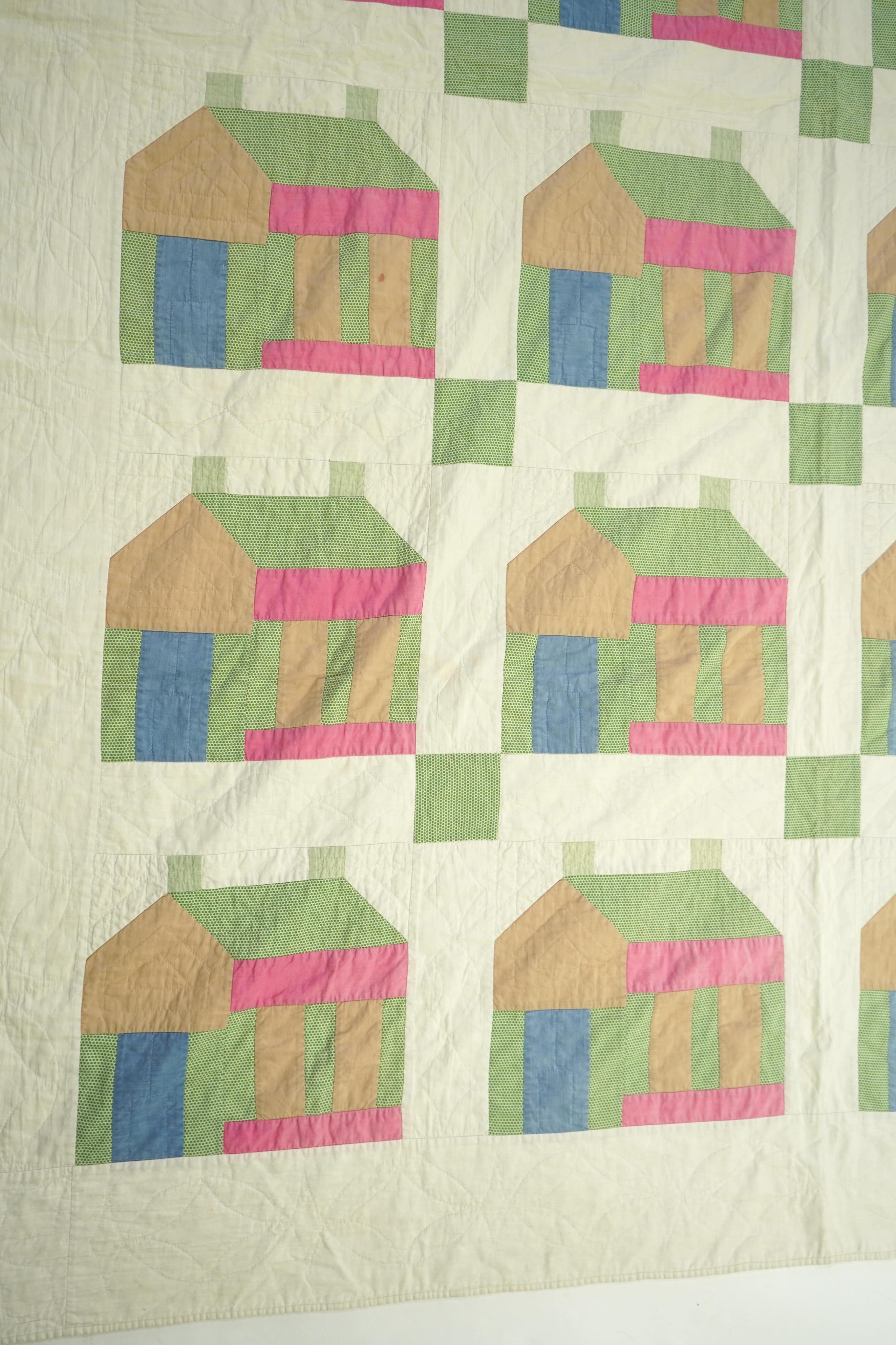 A 1930’s American quilt from Vermont. Quilted in large patchwork ‘house’ motifs, repeating the same four colours in each motif against a plain white background. The reverse a plain white quilted cotton . The quilt hand p